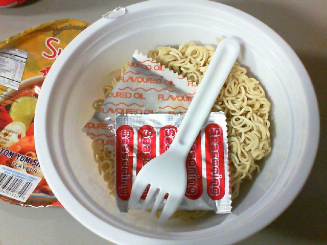 open bowl with noodles packets and little fork